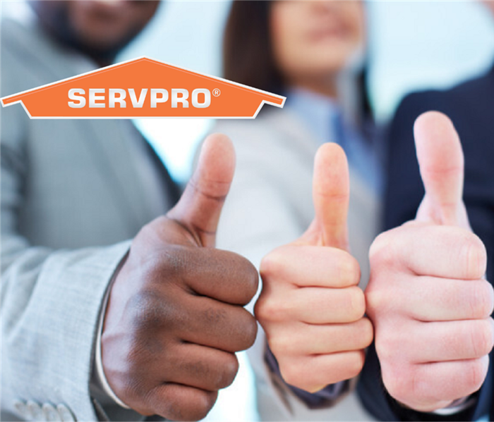 This pictures shows three people giving "thumbs up" and has our SERVPRO logo.