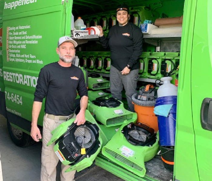 This picture shows two SERVPRO technichans ready to work stepping out of the service vehicle.