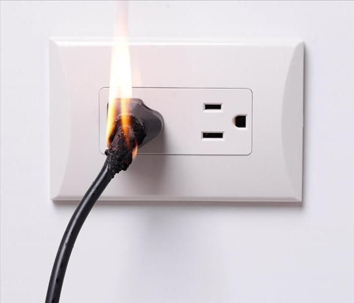 This pictures shows an electrical outlet with smoke coming out of it. 